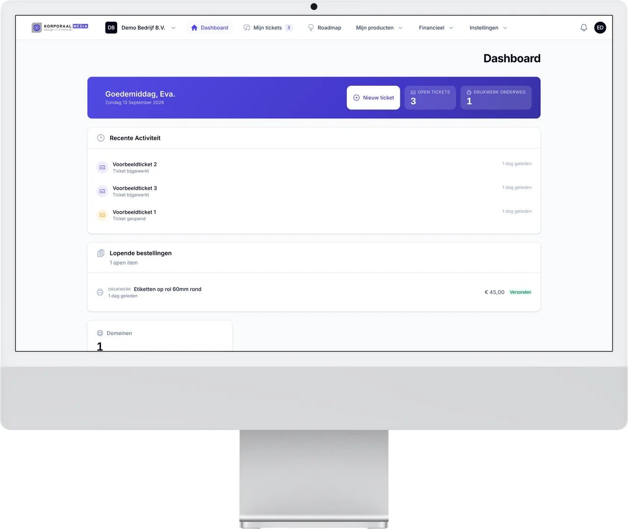 Het klantportaal van Korporaal Media op een iMac: dashboard met openstaande tickets, bestellingen en domeinen